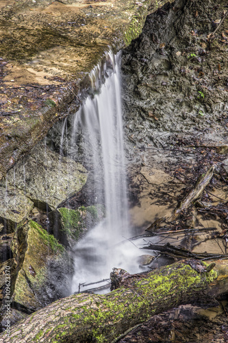 Maidenhair Falls  a small waterfall in Indiana s Shades State Park flows over a rock ledge with a recess cave below.