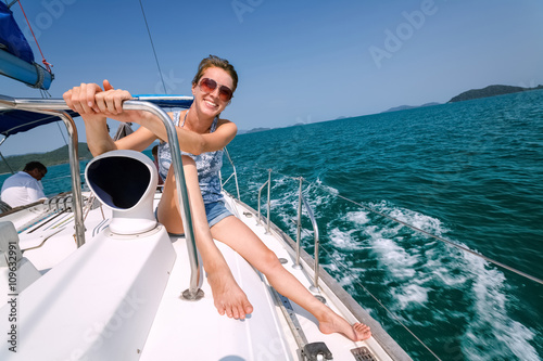 smiling girl in glasses sitting on a yacht