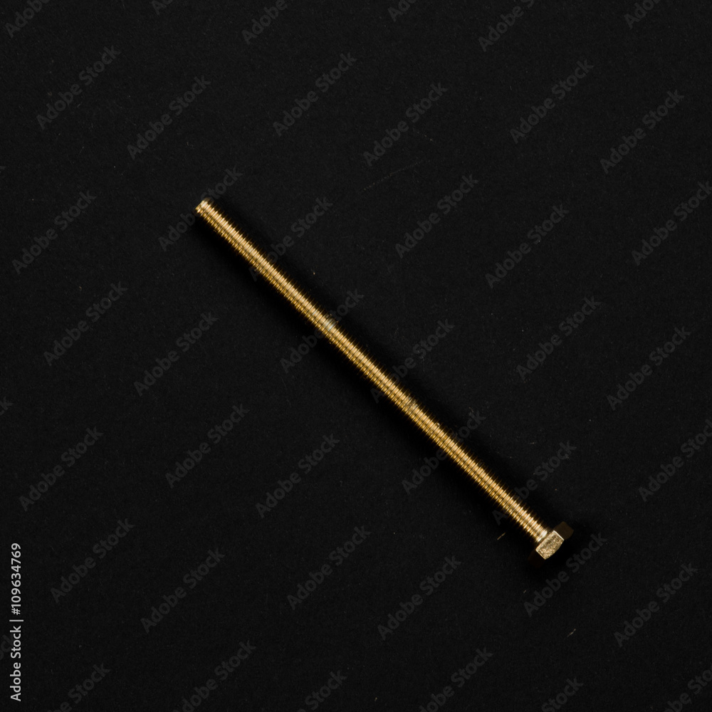 Golden bolt isolated on black background. Symbolic repair tool