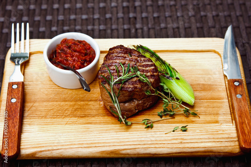 Beautiful juicy well done steak with sauce on a wooden Board photo