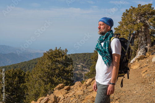 Bearded hiker stands on trail