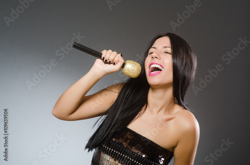 Young woman singing in karaoke club