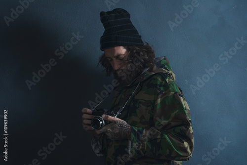 Vintage photographer with beard and long hair wearing camouflage