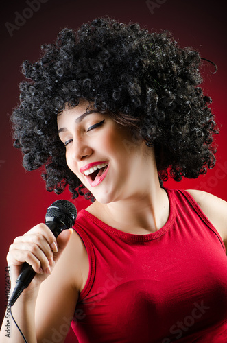 Woman with afro hairstyle singing in karaoke