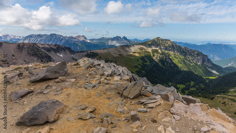 Rocky slopes in the mountains. Amazing view at the peaks which rose against the cloud sky. Path on the tops of mountains. BURROUGHS MOUNTAIN TRAIL, Sunrise Area, Mount Rainier National Park Rocky slopes in the mountains. Amazing view at the peaks which rose against the cloud sky. Path on the tops of mountains. BURROUGHS MOUNTAIN TRAIL, Sunrise Area, Mount Rainier National Park