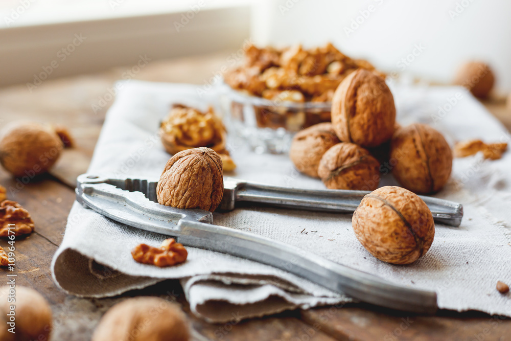 Glass bowl with walnuts on rustic homespun napkin. Healthy snack on old wooden background. Glass bowl with walnuts on rustic homespun napkin. Healthy snack on old wooden background.