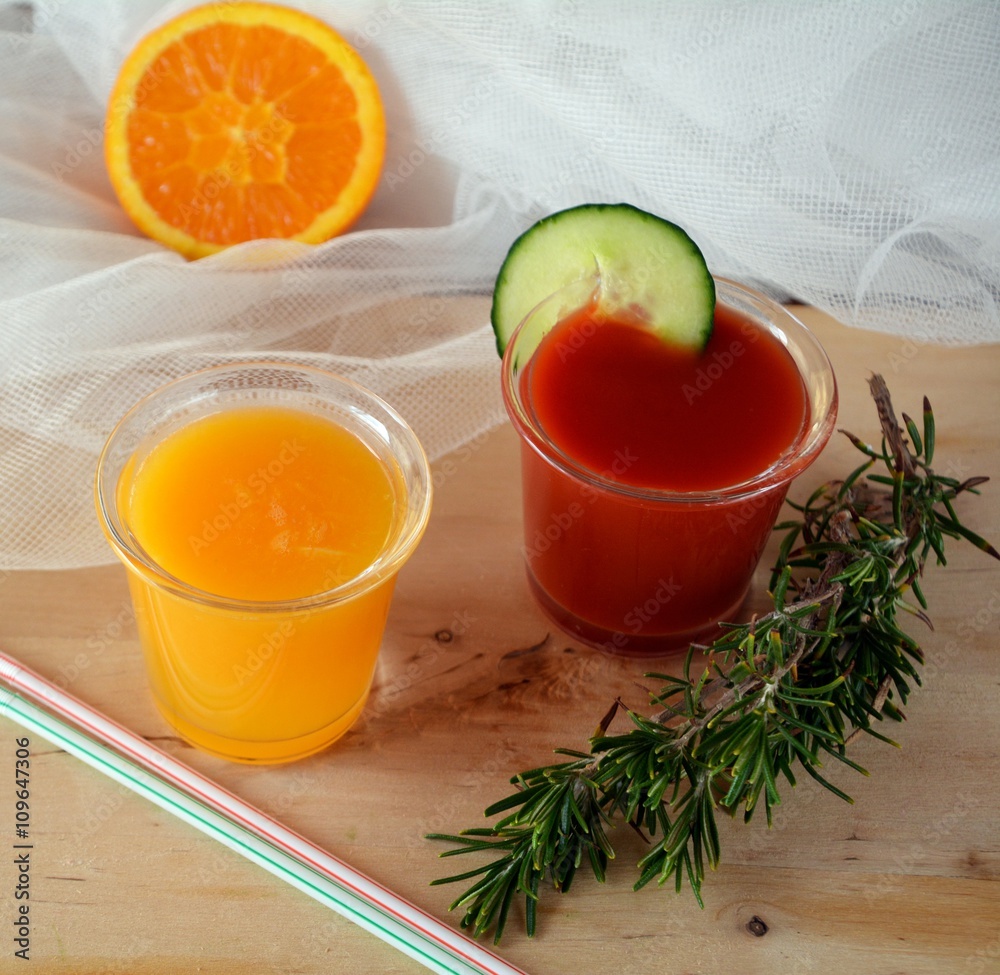 Two glasses of fresh smoothie with orange and tomato Two glasses of fresh smoothie with orange and tomato