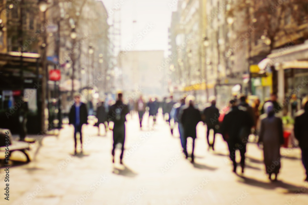 Blurred background. Blurred people walking through a city street Blurred background. Blurred people walking through a city street
