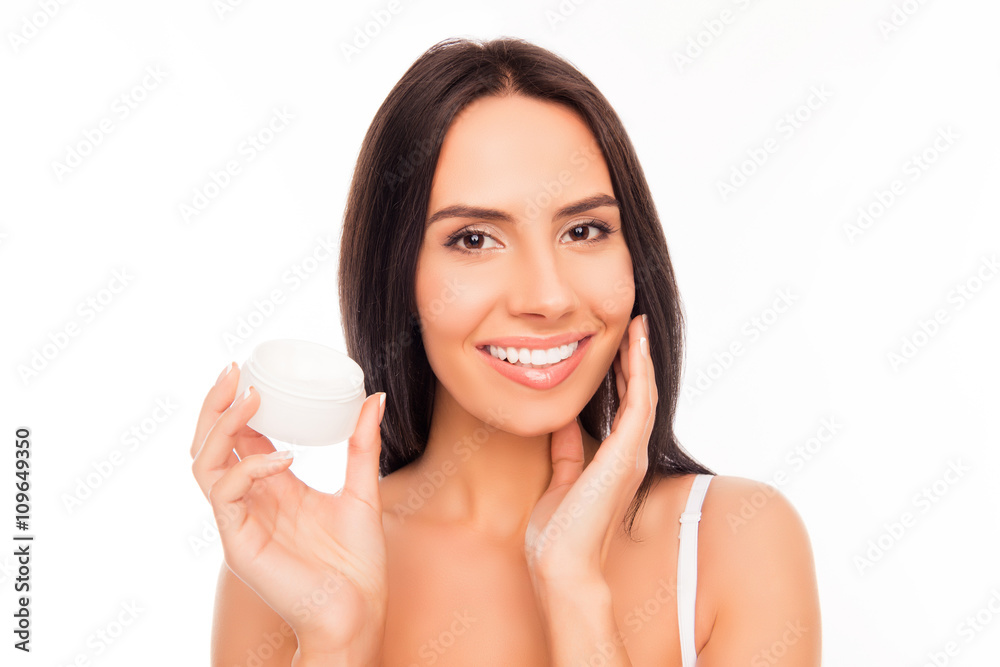 Portrait of pretty woman holding jar and applying cream on her Portrait of pretty woman holding jar and applying cream on her