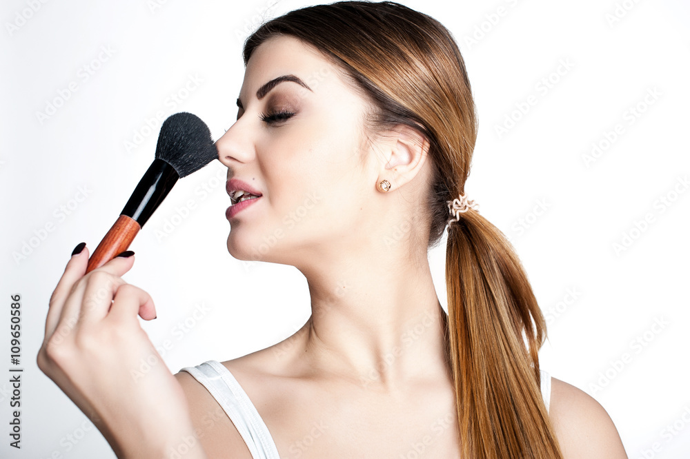 Beauty Girl make up artist with Makeup Brush. Bright Holiday Make-up for Brunette Woman with Brown Eyes. Beautiful Face. Makeover. Perfect Skin. Applying Makeup Beauty Girl make up artist with Makeup Brush. Bright Holiday Make-up for Brunette Woman with Brown Eyes. Beautiful Face. Makeover. Perfect Skin. Applying Makeup