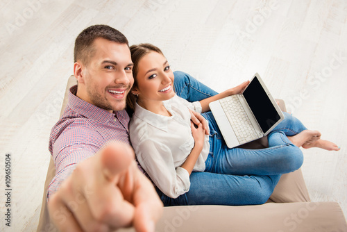 Top view of happy man and woman sitting  on the sofa with laptop photo