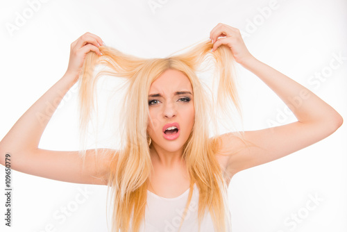 Sad pretty girl showing her damaged hair