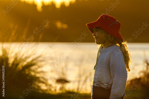 child by the lake at sunset