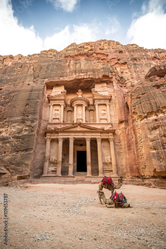 Front view of the famous Al-Khazneh (aka Treasury) with camels resting next to it in the ancient city of Petra (Jordan)