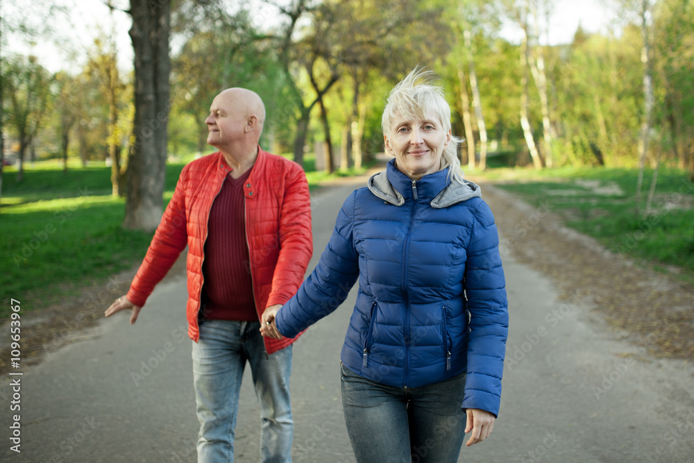 happy seniors couple hold hands and walk; happy seniors couple hold hands and walk;