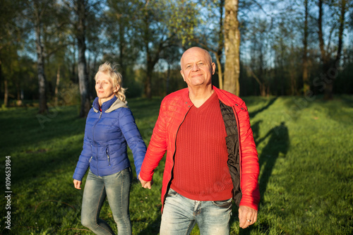 happy seniors couple hold hands and walk;