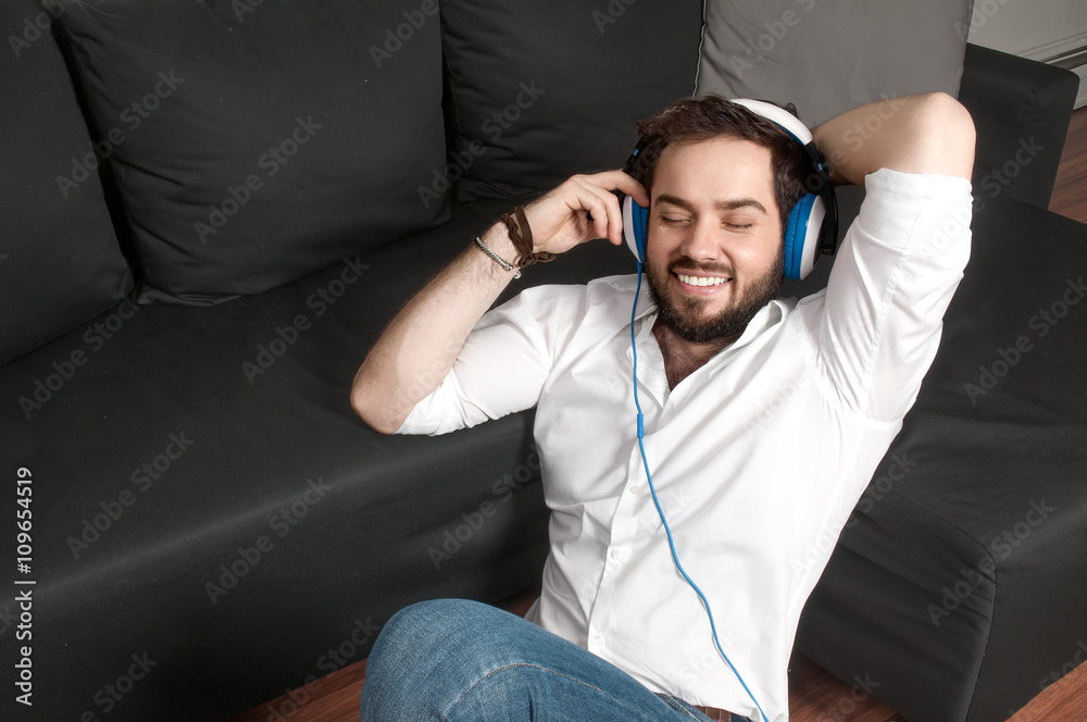Obraz premium Man on a couch in headphone listen to music 