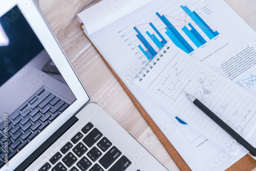 Financial charts on the table with laptop..