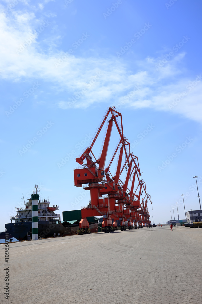 In freight terminal, gantry crane and cargo ships are in loading In freight terminal, gantry crane and cargo ships are in loading