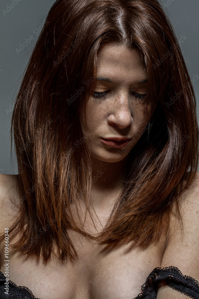 Closeup of a freckled woman looking down Closeup of a freckled woman looking down