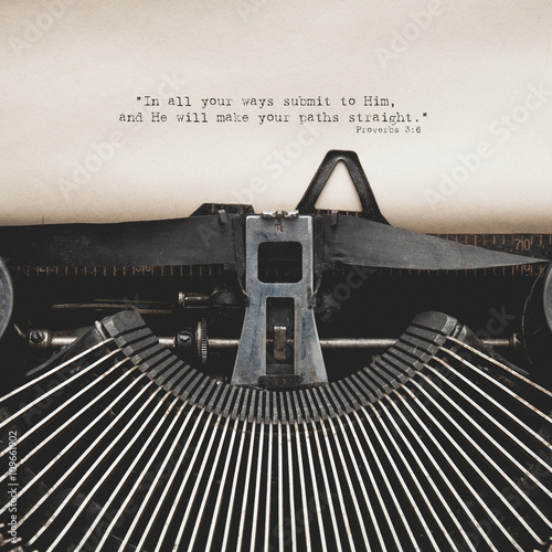 Antique typewriter with aged textured paper sheet. Bible verse o