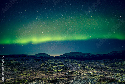 Aurora Borealis over distant mountains © Polarpx