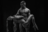 Nude sexy couple. Art photo of young adult man and woman. High contrast black and white muscular naked body