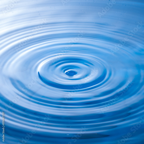 a water drop impact with water surface, causing rings on the sur