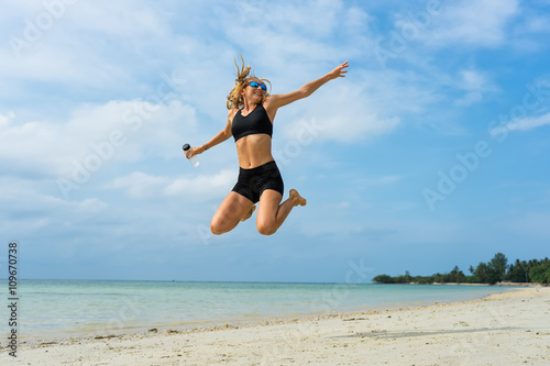 The young girl jumps on the beach of the island Samui
