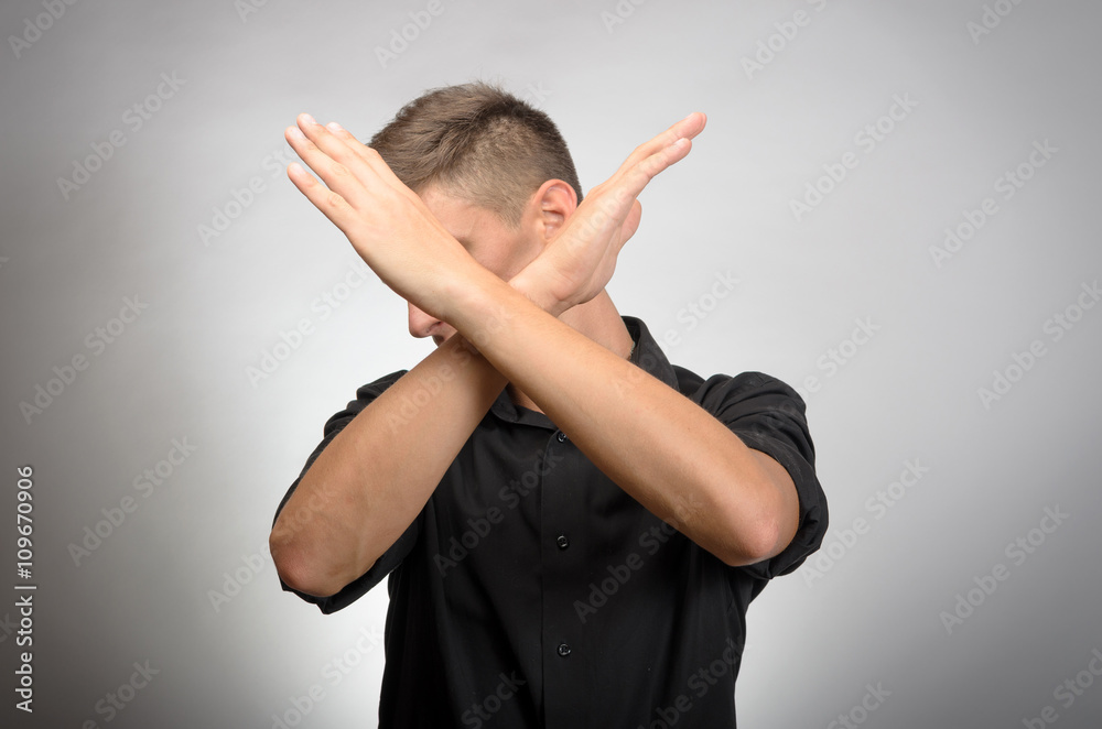 Fotografie Young man making X shape for Extreme with his hands.
