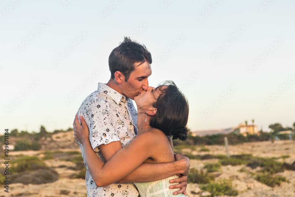 Cute couple kissing outdoors on a sunny day