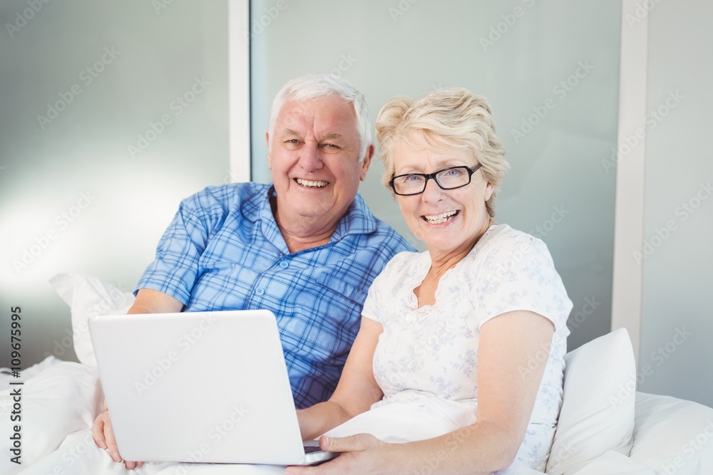 Portrait of happy couple with laptop
