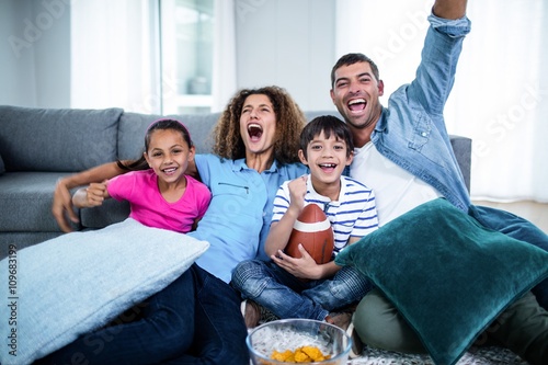Fotografie Family watching american football match on television