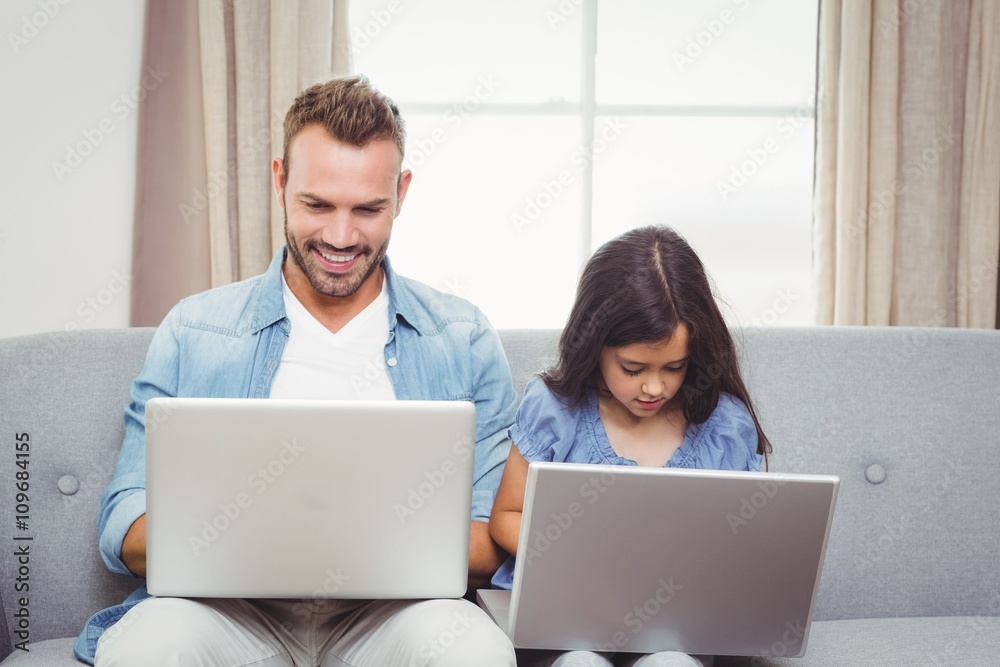 Father and daughter using laptop at home Father and daughter using laptop at home