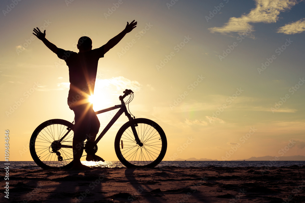 Obraz premium happy man with bicycle standing on the beach
