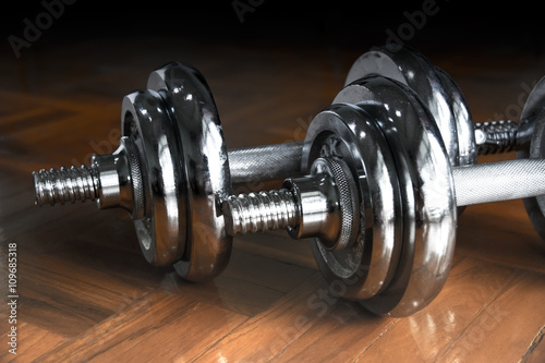 Close up silver dumbbell on floor room