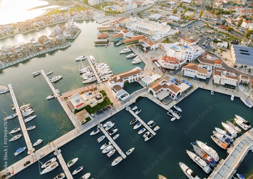 Aerial view of the beautiful Marina in Limassol city in Cyprus,beach,boats,piers,villas and commercial area.A modern,high end,newly developed space with docked yachts and for a waterfront promenade. 