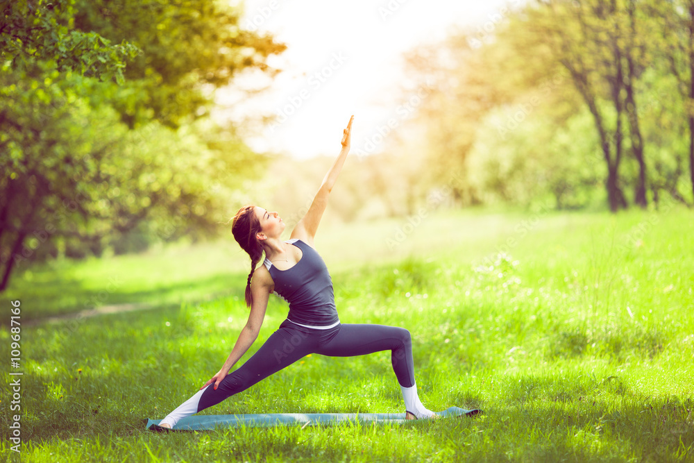Young woman doing yoga in morning park. Young woman doing yoga in morning park.