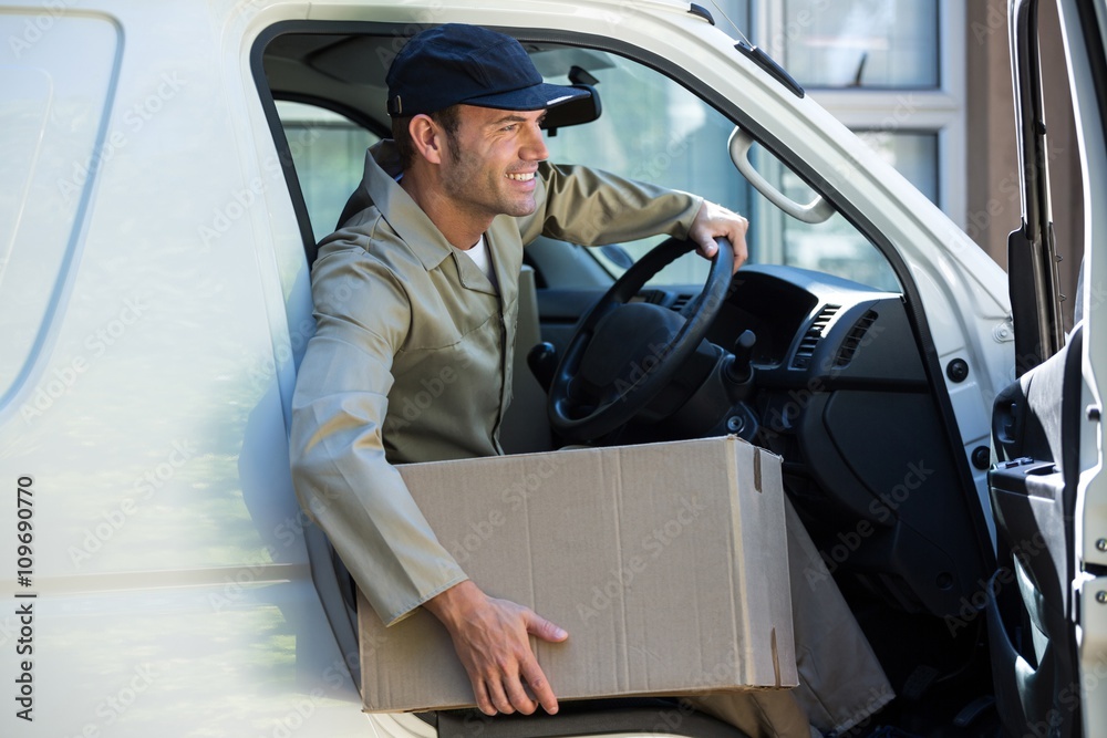 Smiling delivery man getting out from