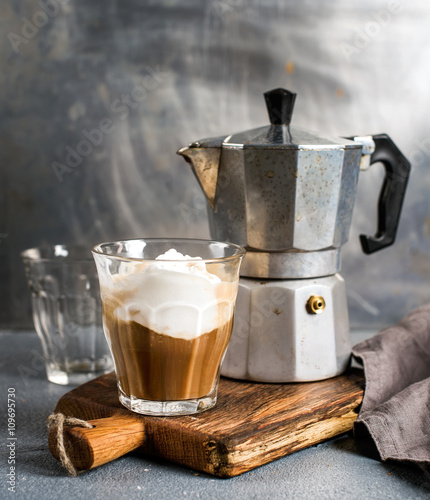 Glass of coffee with ice cream on rustic wooden board and steel Italian Moka pot photo