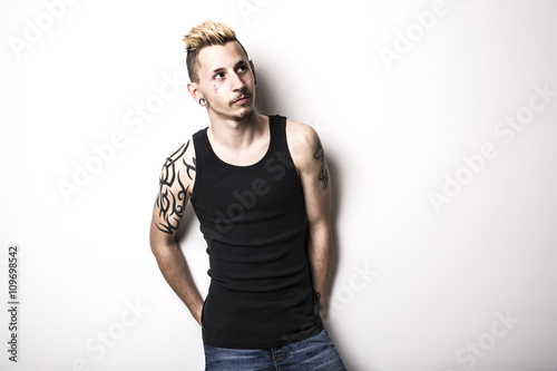 Handsome stylish young man with tattoo and piercing