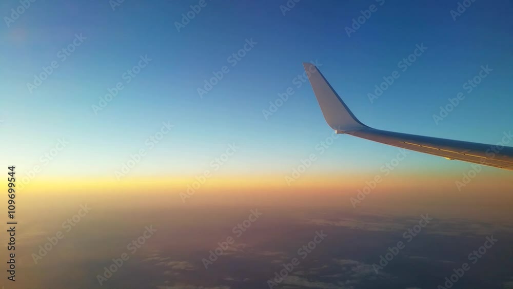 View of an aircraft wing during flight at sunset View of an aircraft wing during flight at sunset