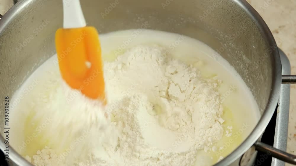 Mixing milk, butter and flour, making the choux dough for Eclairs Mixing milk, butter and flour, making the choux dough for Eclairs