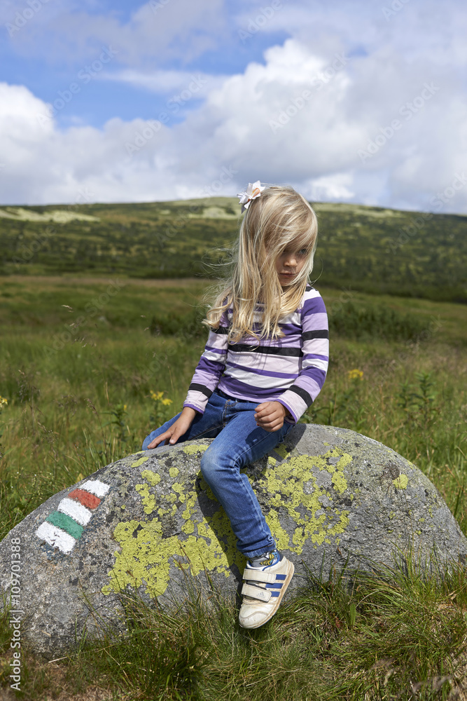 Posing young child blond girl in mountain region Posing young child blond girl in mountain region