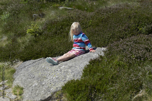 Posing young child blond girl in mountain region