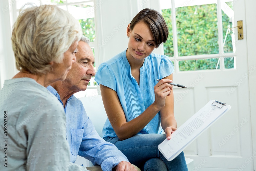 Obraz premium Senior couple reading report with female consultant