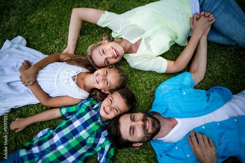 Smiling family lying on grass at yard 