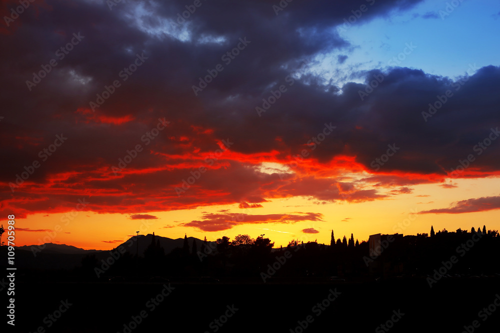 Sunset, cloudy sky background over night city. Nature.