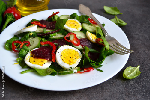 Vitamin salad with spinach, egg and beetroot on a black backgrou © zefirchik06