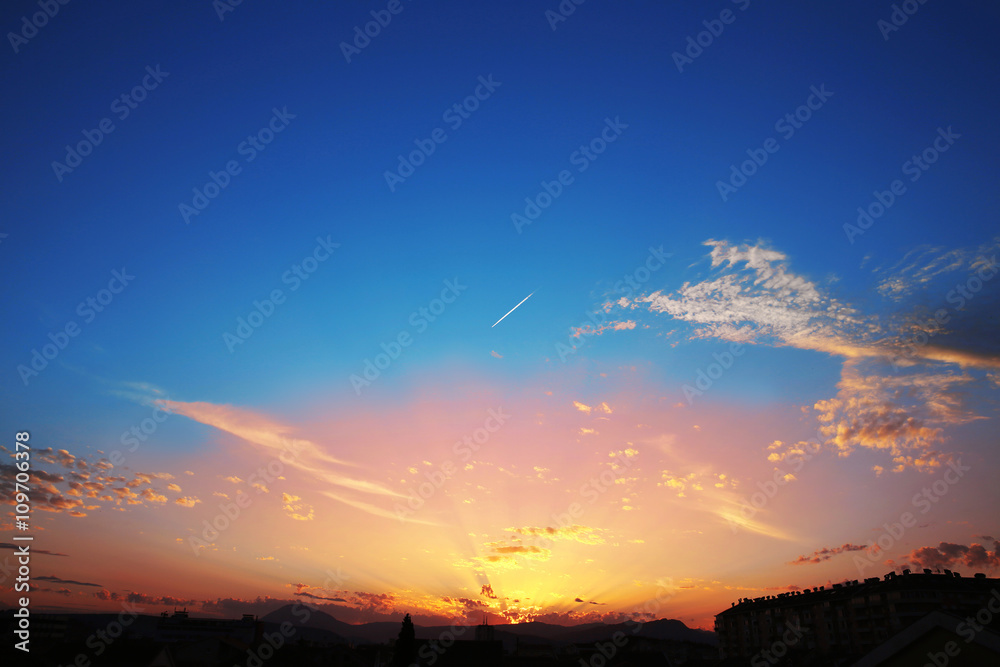 Sunset with clouds, light rays, blue sky, natural background. at